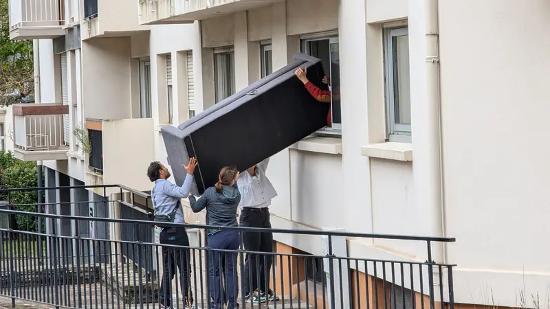 Räumung Zürich: Helfer heben ein Sofa durch das Fenster aus einer Wohnung